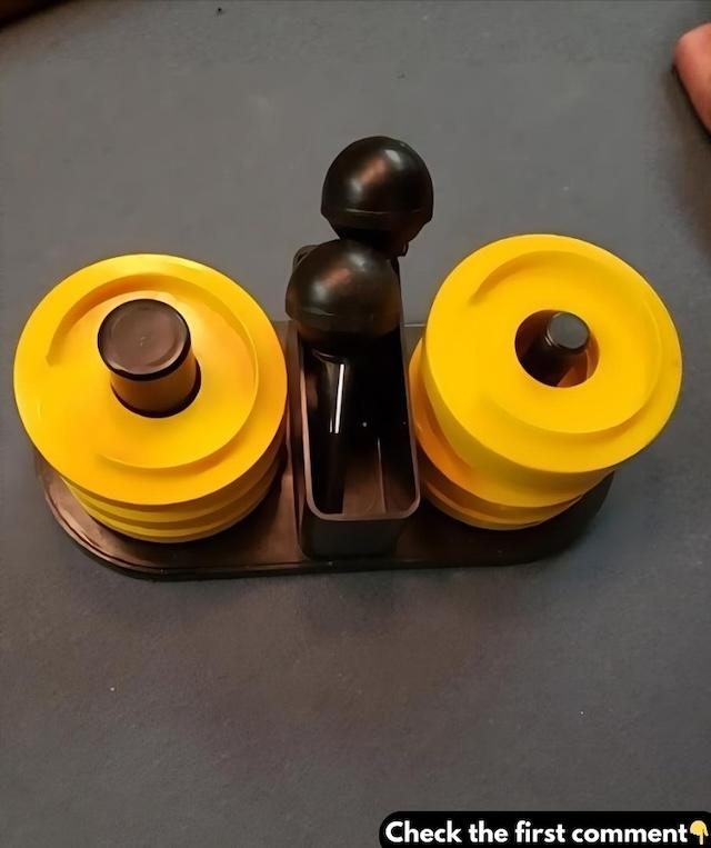 A close-up view of the olfa o weights, showing its distinctive yellow and black design, used to secure fabric for cutting without pins